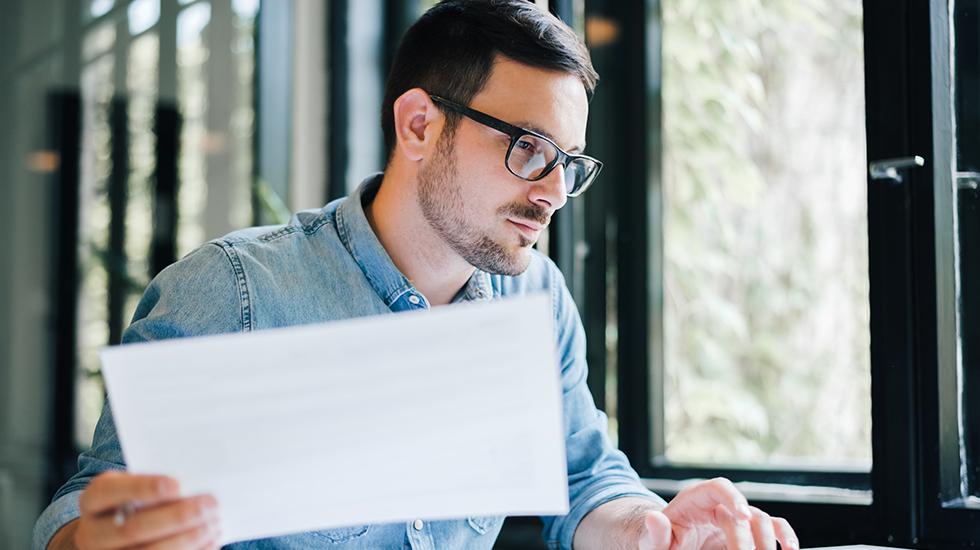 Man wearing glasses examining PEOs and online solutions optoins